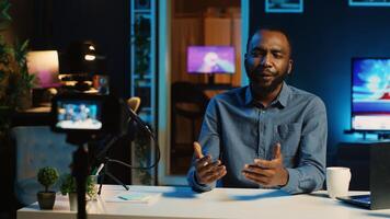 Happy content creator using professional recording devices in cozy studio to film intro for online streaming platforms. Influencer greets fanbase, talking about today topic photo