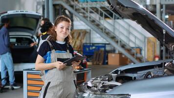 Mechanic in garage workspace using tablet to order new parts for car after finding damages during annual checkup. Expert looking online for automotive components for customer vehicle photo