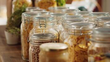 Close up on bulk products in reusable glass jars used by zero waste supermarket to eliminate single use plastics. Local shop pantry staples in sustainable packaging, zoom in shot photo