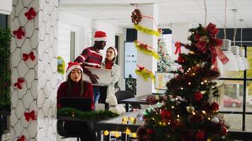 Upset worker in festive ornate office packing desk belongings on last day at work after being fired. Staff member getting consoled by coworker after being laid off before Christmas, saying goodbye photo