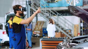 Mechanic in auto repair shop using virtual reality goggles to visualize car components in order to fix them. Repairman wearing futuristic vr headset while working on damaged vehicle photo