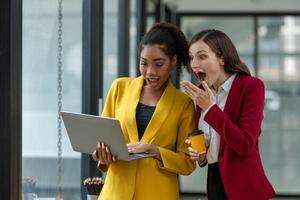 Excited business colleagues discussing over a digital tablet, sharing ideas in a dynamic office setting. photo