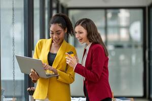 Excited business colleagues discussing over a digital tablet, sharing ideas in a dynamic office setting. photo