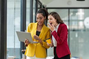 Excited business colleagues discussing over a digital tablet, sharing ideas in a dynamic office setting. photo