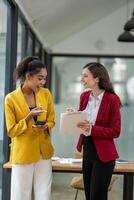 Excited business colleagues discussing over a digital tablet, sharing ideas in a dynamic office setting. photo