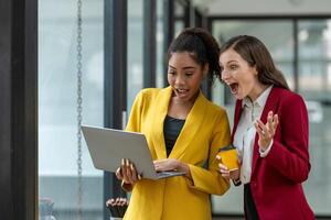 Excited business colleagues discussing over a digital tablet, sharing ideas in a dynamic office setting. photo