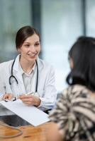doctor notes while listening to her patient's medical history during a thorough and attentive check-up. photo