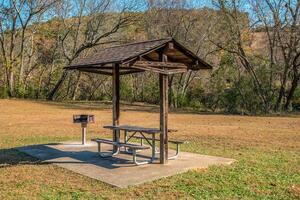 Picnic table and grill in a park photo