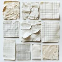 A collection of crumpled and folded grid papers in various sizes and conditions, arranged neatly on a flat surface photo