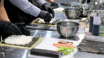 Sushi making process Master class. Step by step set male chef makes sushi and rolls from rice, red fish and avocado. Cook's hands close-up. video