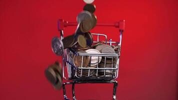 close-up of a shopping cart filled with coins. concept of saving on purchases video