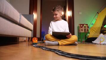 kid play train, toy railroad. boy controls a train on the railway using a tablet video