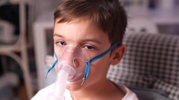 close-up boy being treated for asthma, bronchitis, flu, cough using nebulizer video