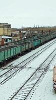 Four rows of containers are located at the railway station near the state building outside the city. Aerial view. Vertical video