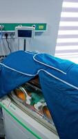 Incubator for newborn children covered with case. Special technological equipment for babies resuscitation in the hospital ward. High angle view. Vertical video