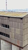 Flight over the empty old plant almost ruined in the city after the war. Old abandoned buildings without windows are broken-down. Camera moves around Vertical video