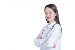 Professional young woman doctor standing with arms crossed smiling wearing white robe and stethoscope at examination room in hospital while isolated white background. photo