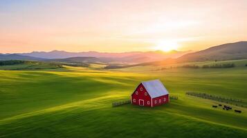 Aerial view of a rustic ranch with sprawling green pastures a classic red barn and grazing cattle under a vibrant sunset sky photo