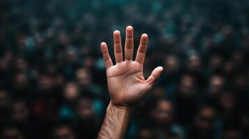 Closeup of a persons hand reaching out desperately through a thick crowd the crowd blurred to highlight the sense of urgency photo