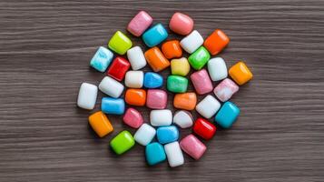Flat lay of a variety of bubble gum wrappers in retro designs arranged in a circular pattern on a wooden surface photo