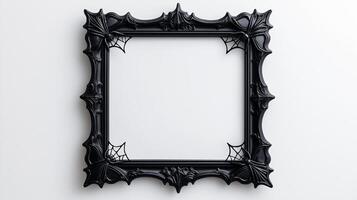 Overhead view of a Halloween style picture frame with ornate black gothic designs featuring spider webs and bat motifs isolated on a white background with soft shadows photo