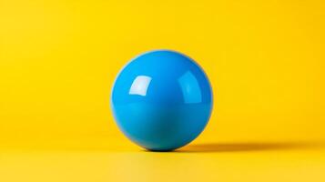 Isolated shot of a single bubble gum ball in bright blue centered on a vibrant yellow background with plenty of empty space photo