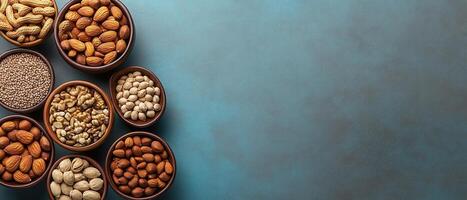 Assorted Nuts and Seeds in Bowls on a Blue Background with Copy Space for Text photo