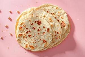Freshly Baked Homemade Tortillas on a Pink Background with Crumbs Scattered Around photo