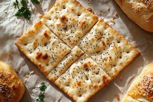 Freshly Baked Flatbread with Sesame Seeds on Rustic Background Surrounded by Artisan Bread Loaves photo