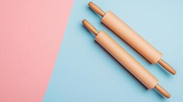Two Wooden Rolling Pins on a Pastel Pink and Blue Background - Kitchen Utensils for Baking and Cooking photo