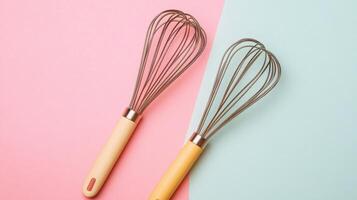 Two Modern Whisks on Pastel Pink and Blue Background - Minimalist Kitchen Utensils photo