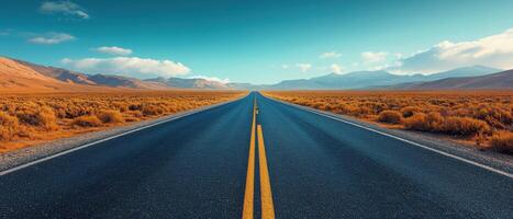 Endless Open Road Through Desert Landscape with Mountains in the Distance Under a Clear Blue Sky photo