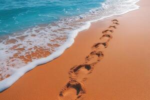 Footprints in the Sand Leading to the Ocean on a Sunny Beach Day with Clear Blue Water and Gentle Waves photo