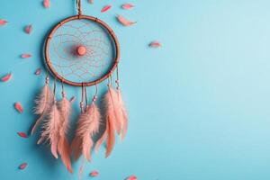 Handcrafted Dreamcatcher with Pink Feathers on Blue Background - Bohemian Decor and Native American Symbolism photo