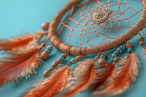 Close-Up of a Handmade Dreamcatcher with Feathers and Beads on a Turquoise Background photo