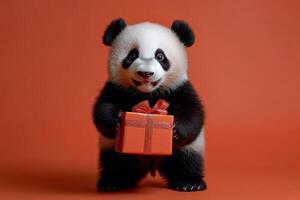 Adorable Baby Panda Holding a Gift Box Against a Vibrant Orange Background photo