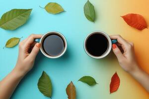 Two Hands Holding Coffee Cups with Colorful Autumn Leaves on a Gradient Background photo
