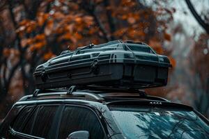 Black roof cargo box installed on a car for a road trip in autumn photo