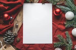 Blank paper surrounded by christmas decoration on red fabric photo