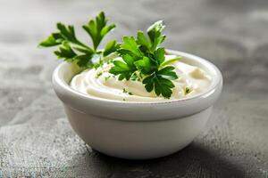 Bowl of mayonnaise sauce with parsley on dark background photo