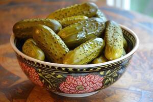 Bowl overflowing with green dill pickles on table photo