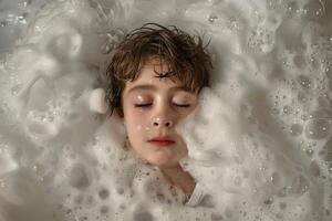 Young boy is having a relaxing bath full of soap bubbles photo