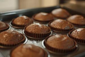 Delicious chocolate muffins cooling on a metal baking sheet photo