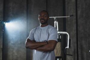 Fitness workout in gym. Portrait of African American man standing in gym with motivation health energy ready for training. Athletic coach personal trainer fitness club owner. Healthy lifestyle photo
