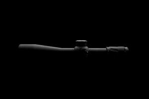 Modern sniper scope on a dark back. Optical device for aiming and shooting at long distances. photo