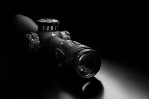 Modern sniper scope on a dark back. Optical device for aiming and shooting at long distances. photo
