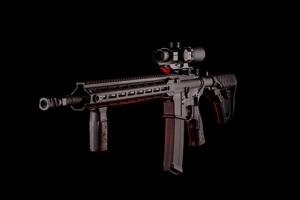 Modern automatic rifle isolated on black background. Weapons for police, special forces and the army. A carbine with optical sights on a dark back. photo