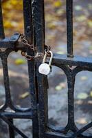 Antique lattice gates closed on a chain with a padlock. The passage is closed. photo