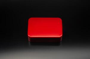 Red metal box of a rectangular background on a black gradient background. Mockup of bright packaging for a small gift. Dark back. photo