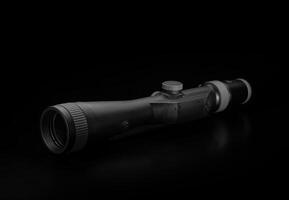 Modern sniper scope on a dark background. Optical device for aiming and shooting at long distances. photo